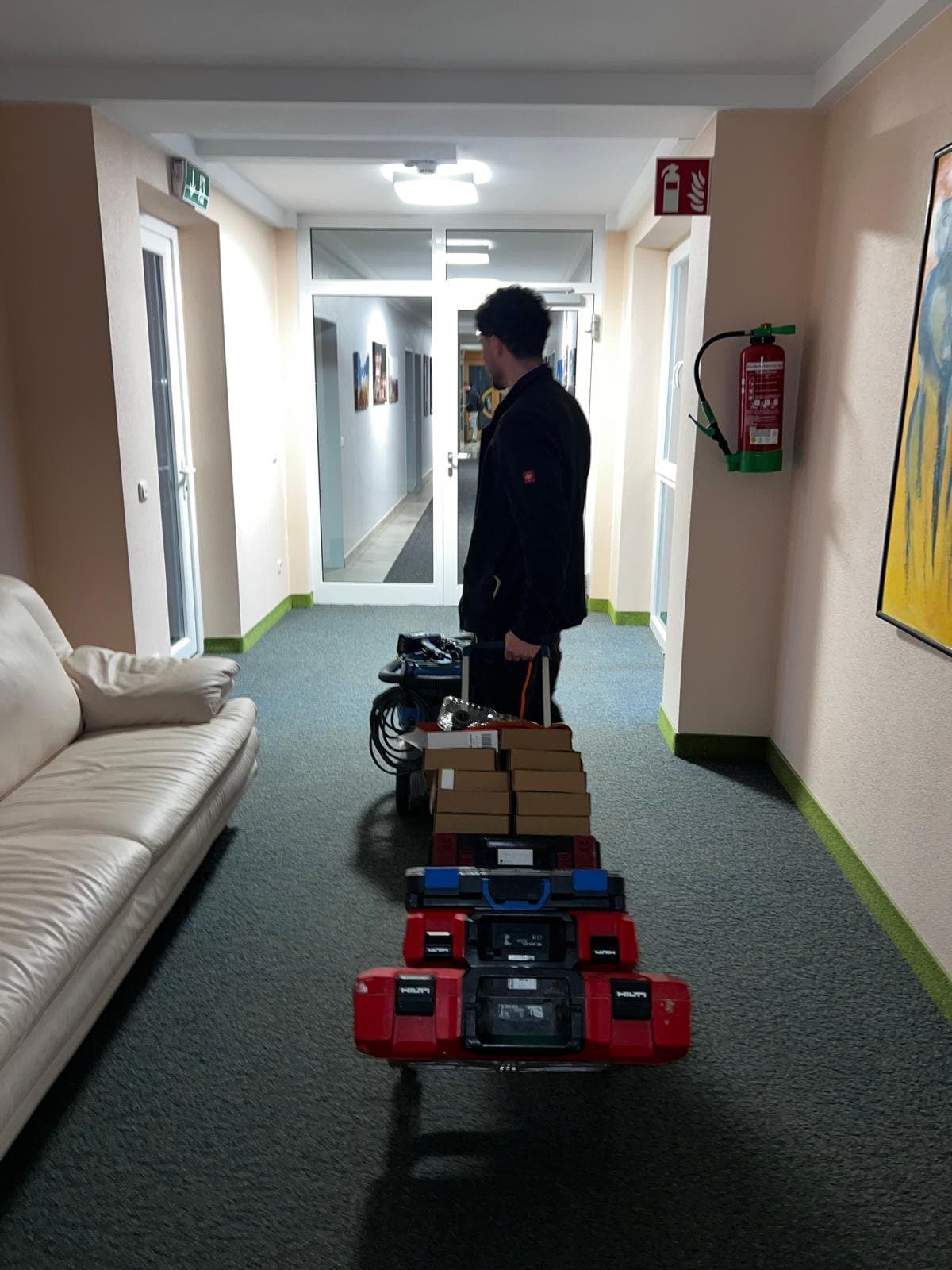 Mitarbeiter von Sofu Elektrotechnik mit Werkzeugkoffern und Material auf dem Weg zum Einsatz